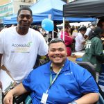 Photo of Accessible Dispatch Outreach Coordinator and Community Emergency Response Team Liaison in a wheelchair at the 2018 Disability Pride Parade.