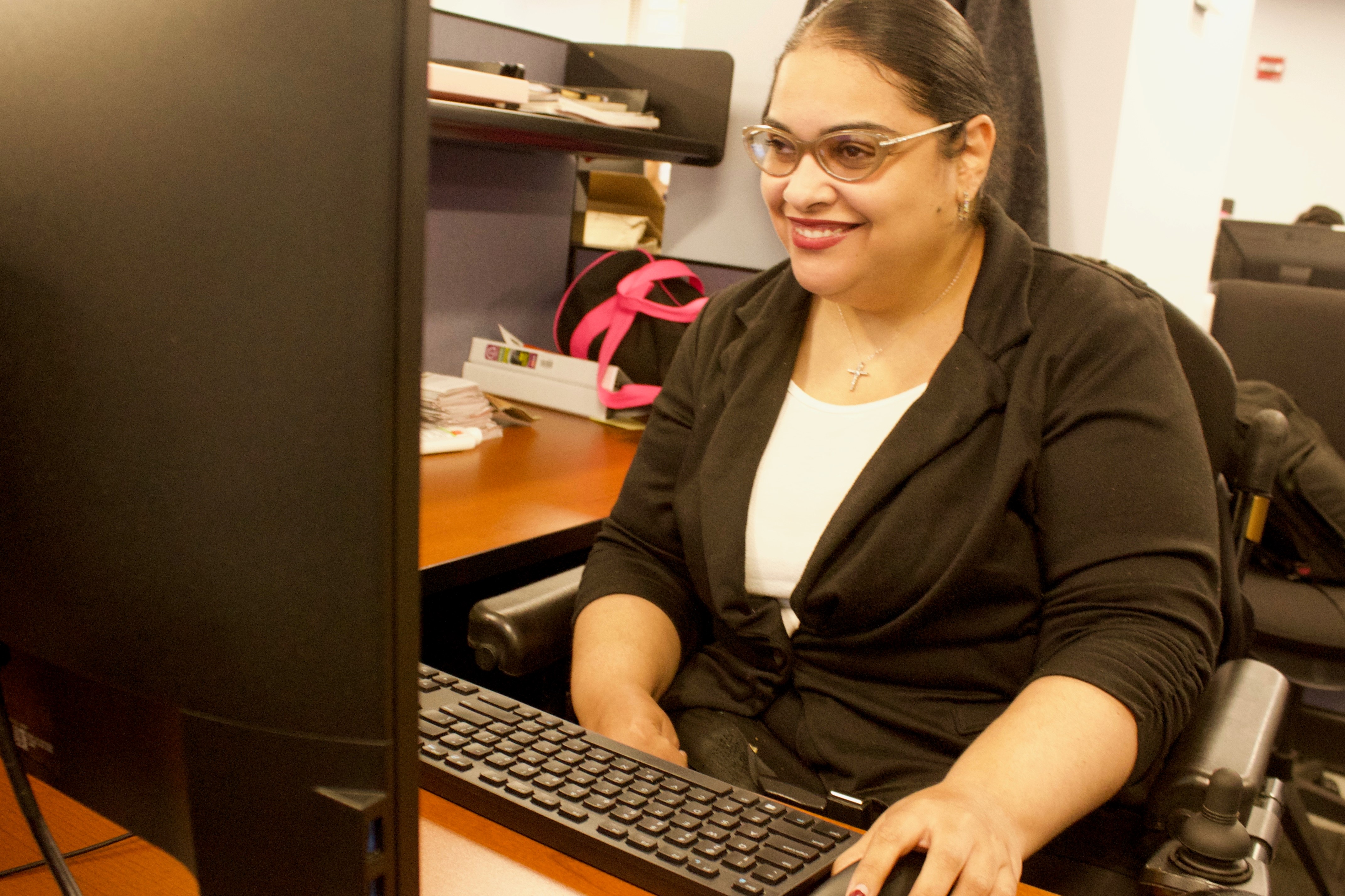 Crystal Rivera, Program Officer for Special Projects, Office of Financial Empowerment/EmpoweredNYC, working diligently on a computer at her desk.